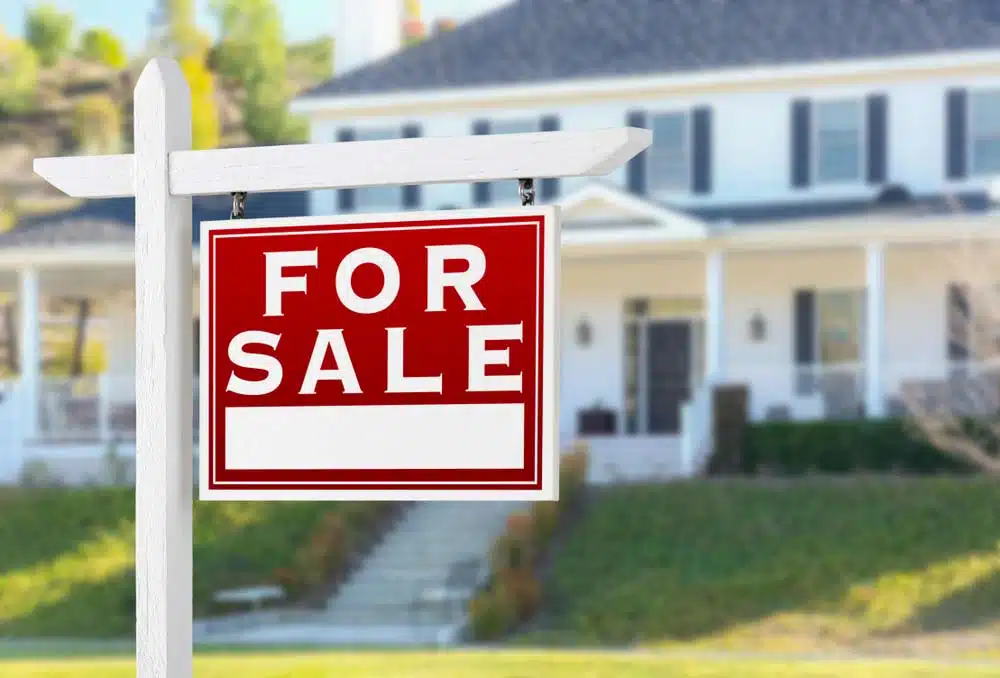 For Sale Sign With Residential House In The Background