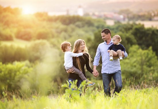 Family Walking On Grass — Property Lawyers In Central Coast, NSW